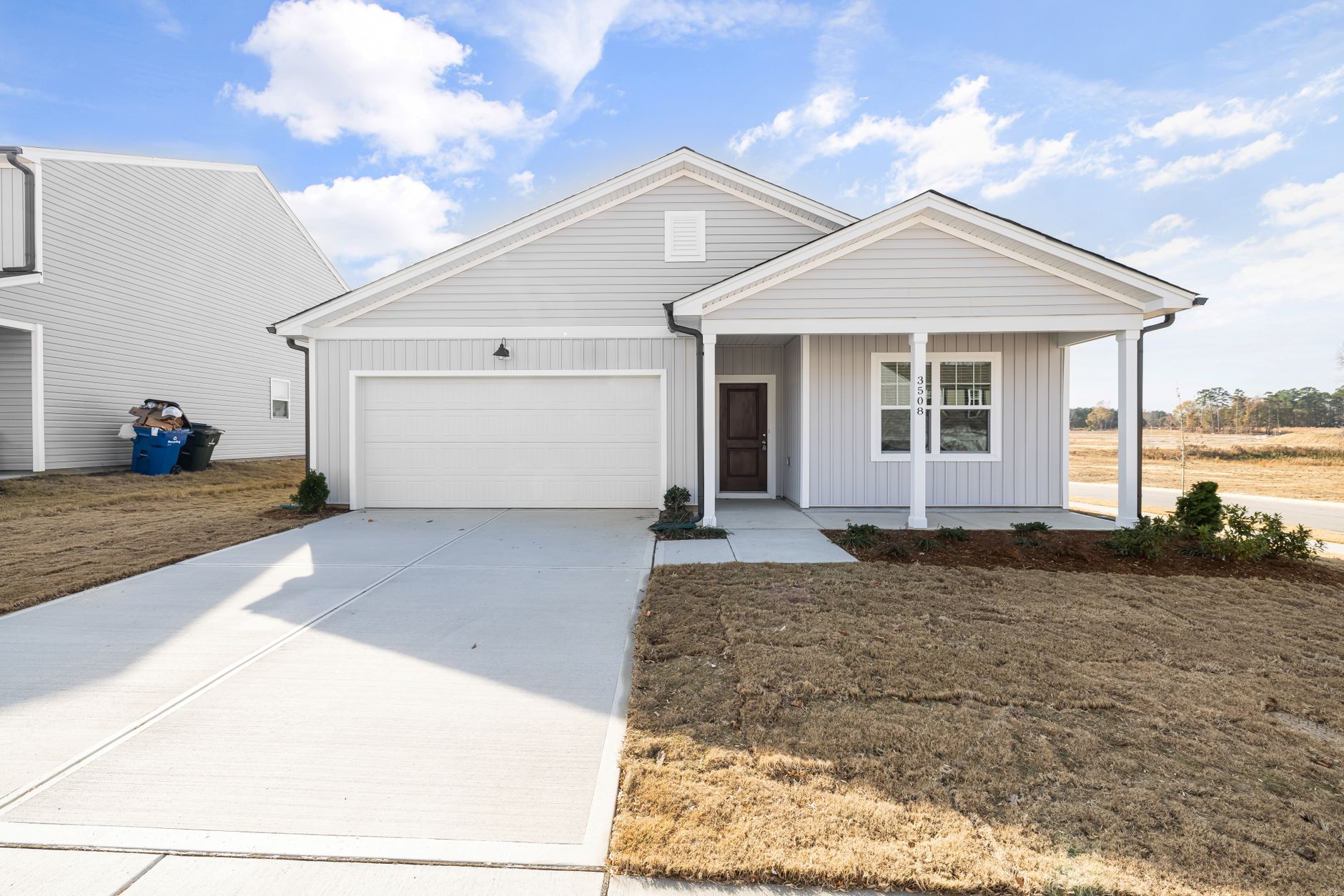 Exterior view of a modern single-story family home with a driveway and front yard.