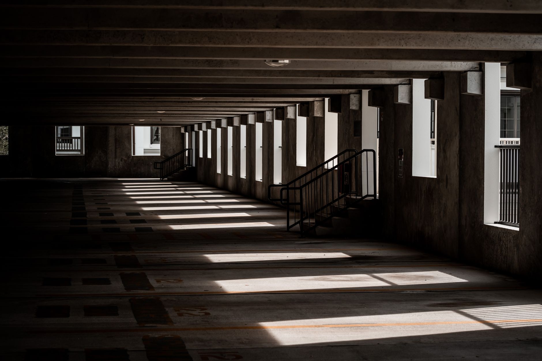 Empty parking garage interior with dramatic shadows and light play.