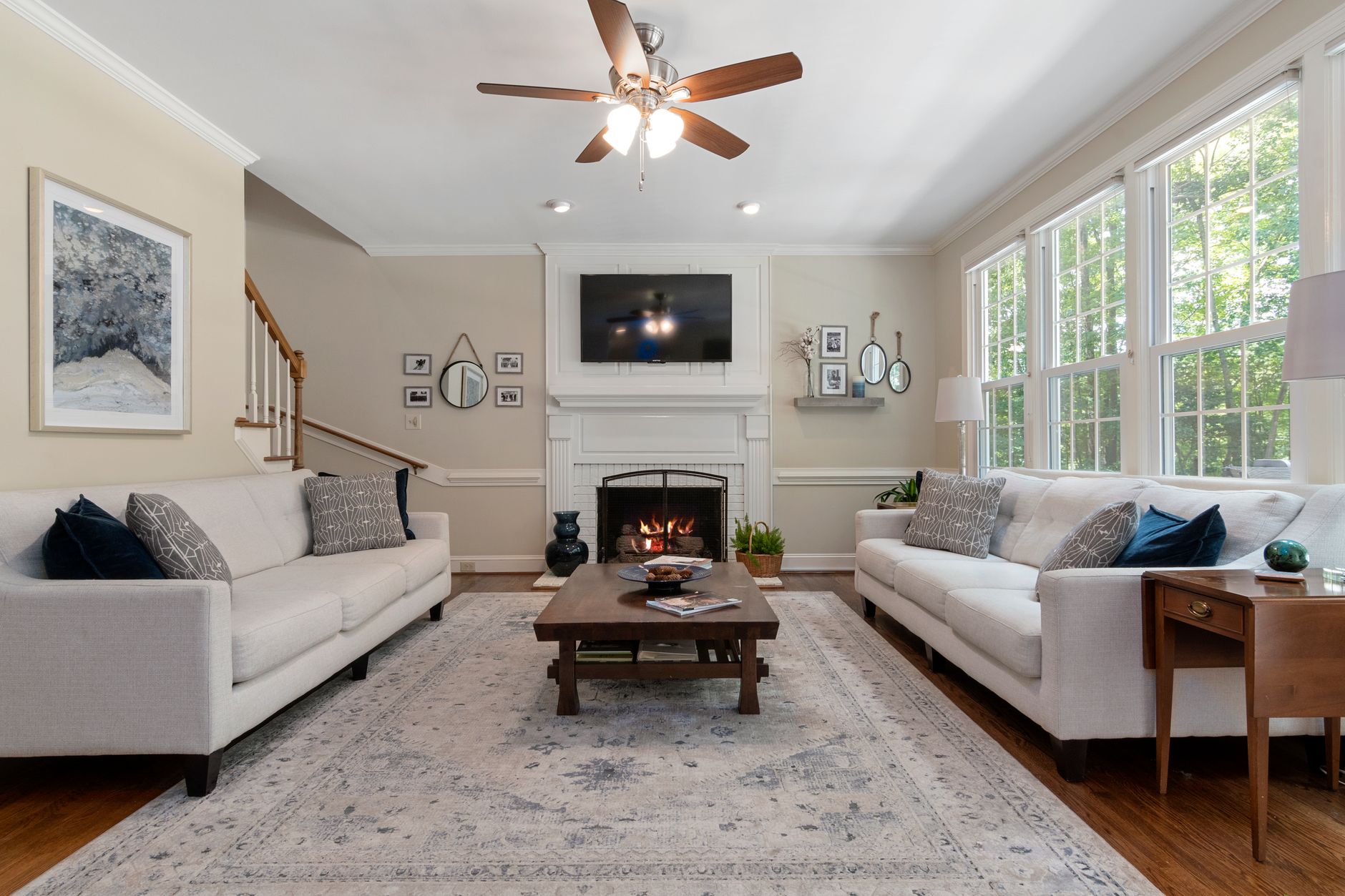 A beautifully designed living room featuring a modern fireplace, elegant furniture, and ample natural light.